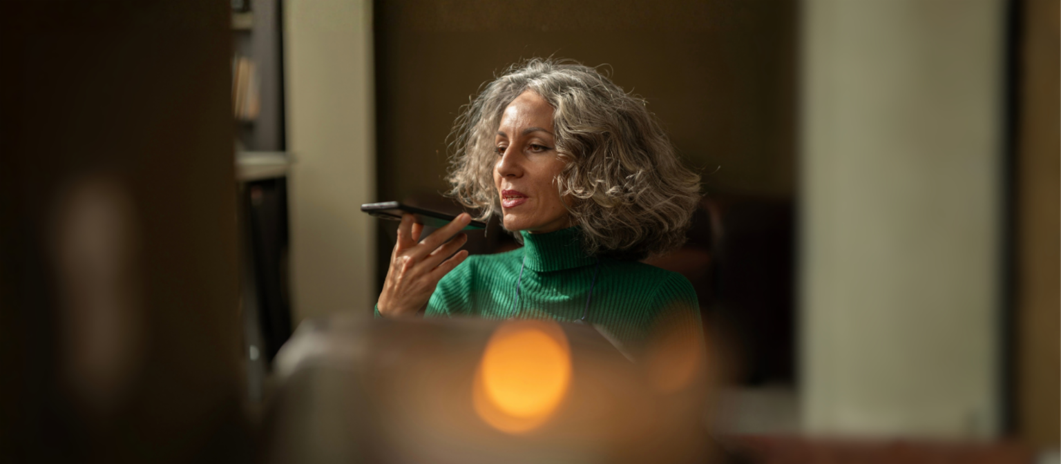 A woman holding a mobile phone is talking to AI.